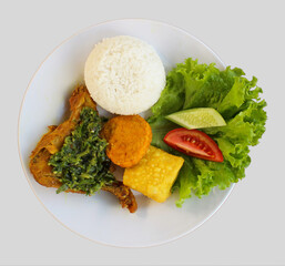 Indonesian cuisine - Ayam Penyet Sambal Ijo or Crushing fried chicken and in a spicy served by green chili sauce, tofu, tempeh, and rice. 