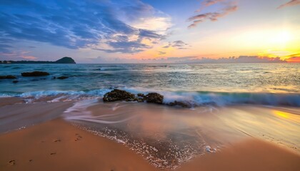 Beautiful beach on sunrise below the waves lapping - obrazy, fototapety, plakaty