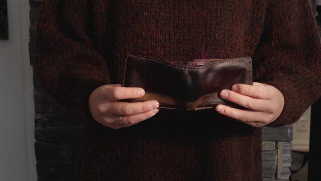Woman holding empty wallet, flames coming from billfold. Financial concept, 60fps
