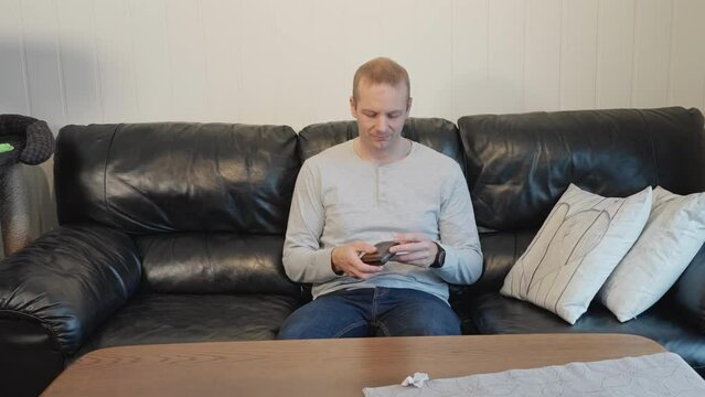 Adult man on couch breaks down after discovering his wallet is empty