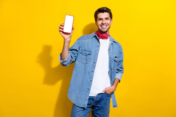 Photo portrait of handsome young guy hold white screen device wear trendy jeans outfit isolated on...