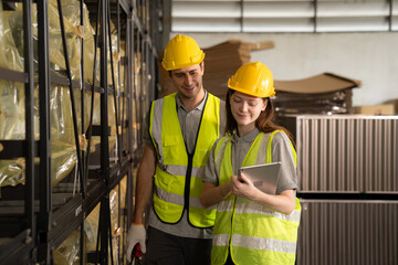 Warehouse worker and managers check stock and inventory by using digital tablet computer in the retail warehouse full of shelves with goods. Working in logistics and distribution center.