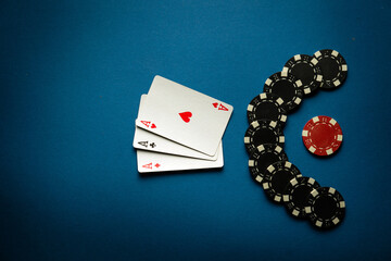 A popular poker game with a combination of three of a kind or set. Chips and cards on a blue table...