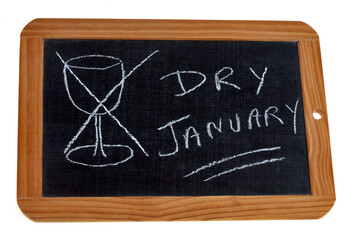 Concept de dry january avec une ardoise scolaire sur laquelle est écrit un texte et un verre à vin dessiné et barré