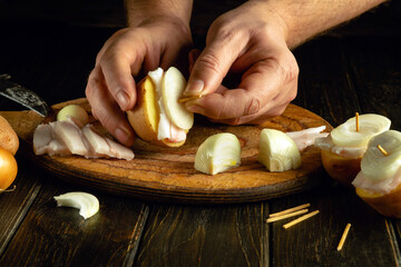 The cook prepares lard with potatoes and onions before baking in the oven. Delicious and quick...
