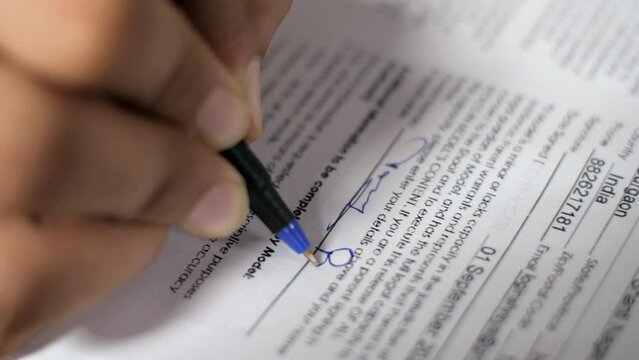 Closeup shot of signing an important document with pen - financial investment  partnership agreement  legal settlement. Closeup shot of a man signing an employment contract - purchasing/renting pro...