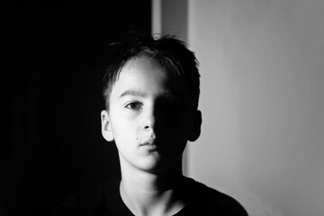 Unusual portrait of a boy, lightened from aside, black and white