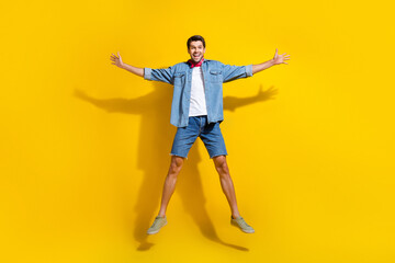 Fototapeta na wymiar Full size photo of good mood ecstatic guy wear jeans jacket shorts jumping celebrate black friday isolated on yellow color background