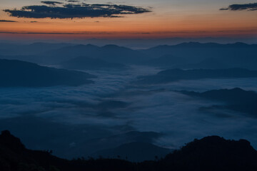 A village that is covering with sea of fog in a valley a sunrise time