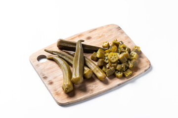 Okra slices on cutting board isolated on white background