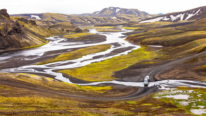 Campervan crossing a river in wild nature of Iceland. Highland panorama in remote volcanic scenery with rivers, mossy hills and original surrounding. Four wheel outdoor experience and  adventure. - obrazy, fototapety, plakaty