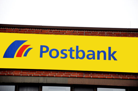 Postbank Logo: Filialen Marke sowie Zweigniederlassung der Deutschen Bank in gelb mit blauen Buchstaben.