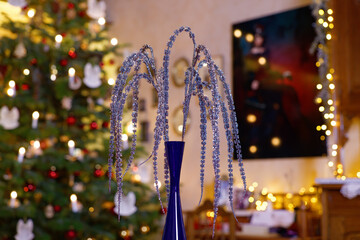 Weihnachtliche Tischdekoration mit hängenden Glitzerzweigen in festlich geschmücktem Wohnzimmer