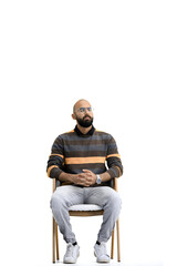 A man, on a white background, is sitting on a chair
