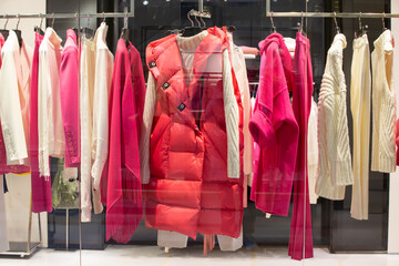 Women's clothing in red and white colors behind the glass of a store window.