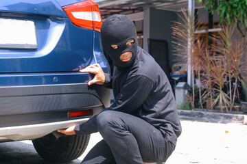 Masked thief in action before burglary. Car thief criminal concept.