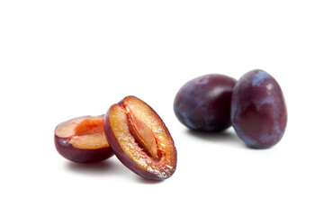 Two Whole and Halves purple plums isolated on white background. .
