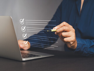 Businesswoman use a pen to tick the correct sign mark for quality control assurance of the ISO...