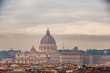 Fototapeta na wymiar View of St. Peter's dome and the rooftops of Rome on a cloudy winter day