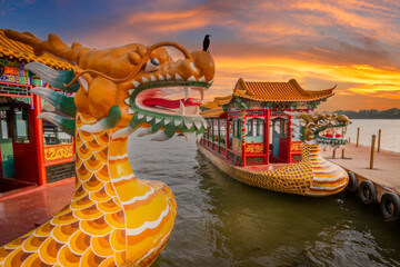 Traditional Chinese Dragon Boat, at Sunset, Glides on a Peaceful Lakes Surface