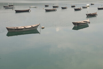Insieme di barche sulla superficie di un lago verde e limpido