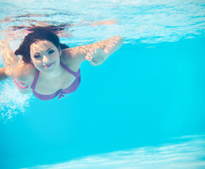 Obraz na płótnie Canvas Underwater woman portrait in swimming pool