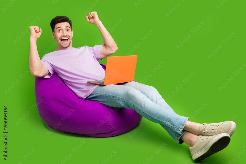 Sticker Full length photo of overjoyed nice man dressed stylish clothes sitting pouf rejoicing sale empty space isolated on green color background