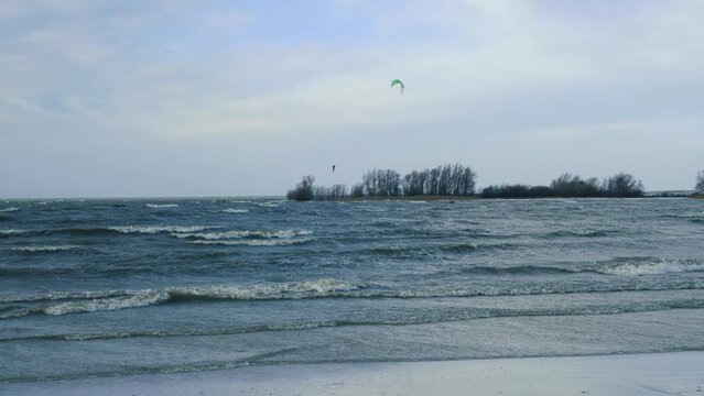 Kitesurfing, kiteboarding in wintertime, Ijsselmeer, Netherlands