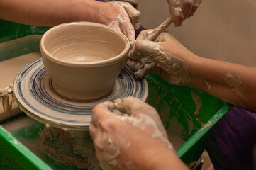 Clay, ceramics or hands in a design workshop working on an artistic cup or mug. The hand of a creative artist or worker making crafts in sculpture