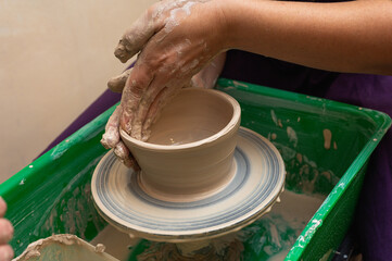 Clay, ceramics or hands in a design workshop working on an artistic cup or mug. The hand of a creative artist or worker making crafts in sculpture