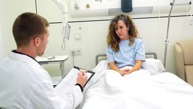 Doctor talking to a patient while visiting her in the room