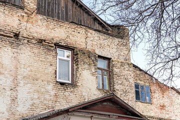 Fototapeta na wymiar Old wooden double sash window and PVC white window. Brick wall