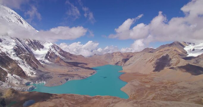 World Highest Altitude Tilicho Lake in Nepal landscape of Annapurna Mountain Circuit, drone shot revealing beautiful lake under the pleasant weather, clouds, blue sky, snow, and land 4K