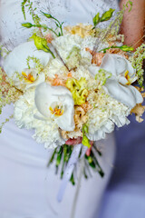white bouquet in the hands of the bride