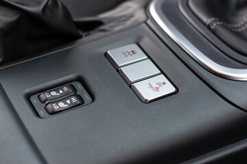 A closeup photo of traction control button on dashboard of modern sport car