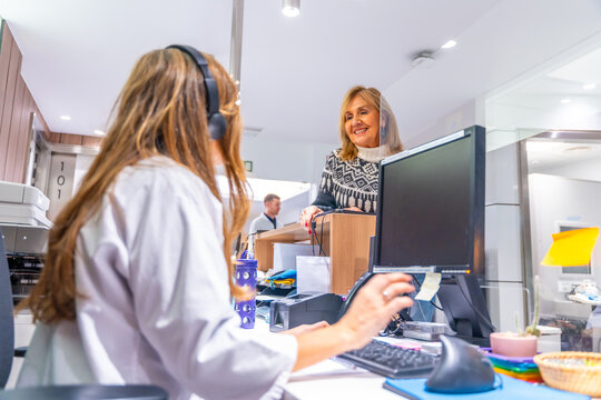 Receptionist of an hospital attending a mature woman