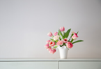 pink spring flowers in white ceramic vase in modern home interior - obrazy, fototapety, plakaty