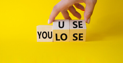 You use or lose symbol. Businessman hand Turns cube and changes word You lose to You use. Beautiful...