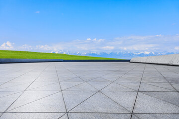 Empty floor and green grass with mountain nature landscape under blue sky