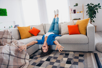 Photo of cheerful glad girl lying on sofa have fun spending weekend time alone indoors