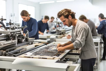 Foto op Plexiglas A group of men working on large printers in a factory. Printing industry machines. Plotter for large prints. © Degimages