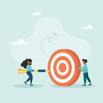 An employee tries to throw a dart at a large concentric dart board held by a leader, a concept for motivating employees to achieve goals.

