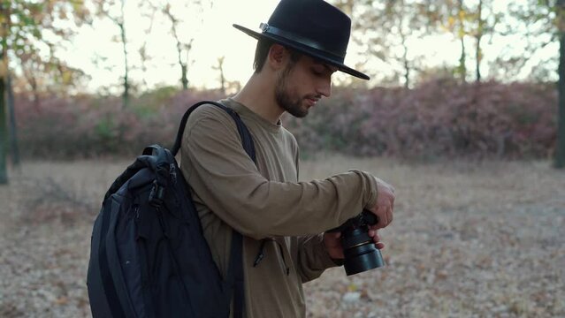 Photographer with a professional camera in the autumn forest photographing nature