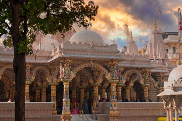 Sunrise at Ornate Hindu Temple with Golden Domes, Traditional Carvings, and Devotees in India