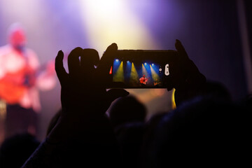 Capturing the Evening Entertainment: Group of People Enjoying a Popular Music Concert