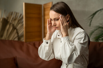 A tired woman with a severe headache. A young girl in a state of stress, suffering from acute...