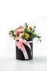 Flower arrangement in a hat box, a pot of roses and orchids on a white background