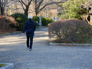 冬の東京都の町で散歩する男性の姿