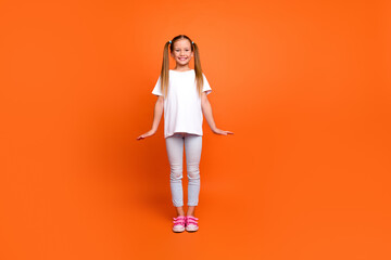 Full body photo of charming little girl cute charming posing wear trendy white clothes isolated on orange color background