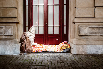 Bed of homeless person in front of urban house, Porto, Portugal